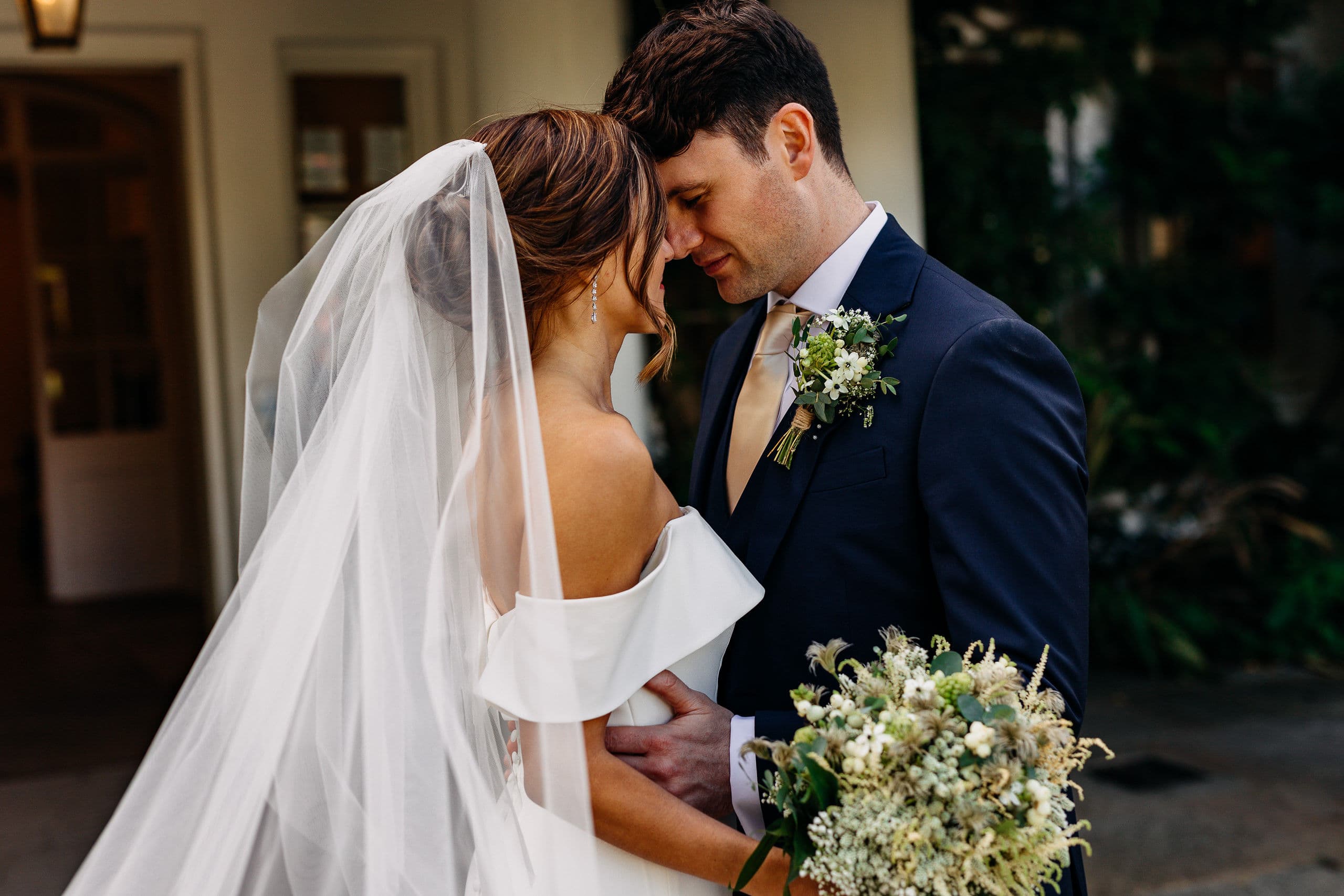 A bride and groom sharing a quiet moment with their foreheads together