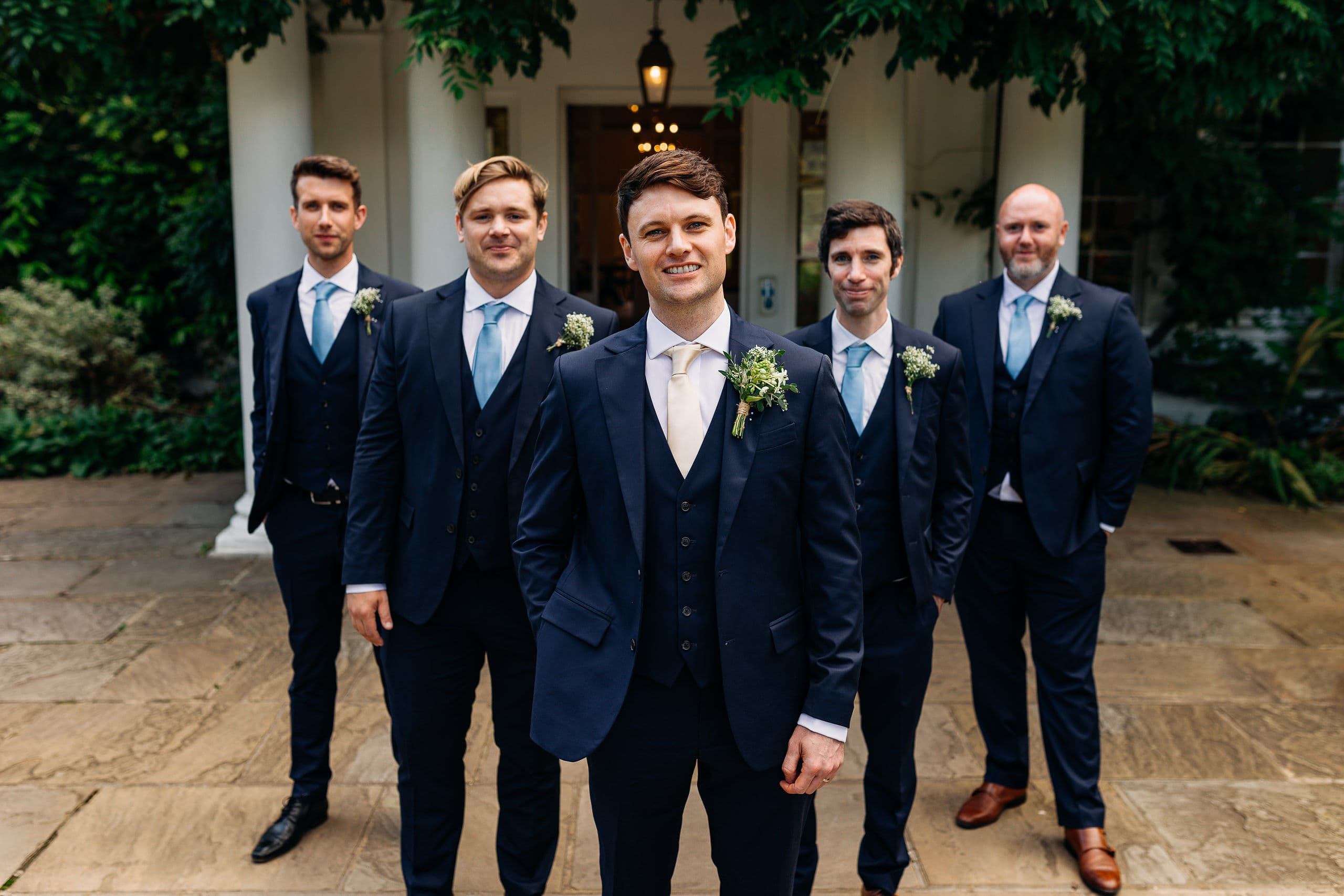 A groom standing with his groomsmen outside a UK wedding venue